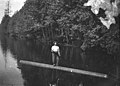 Logger poling down river or lake on log, Washington, approximately 1909-1910 (INDOCC 1410).jpg