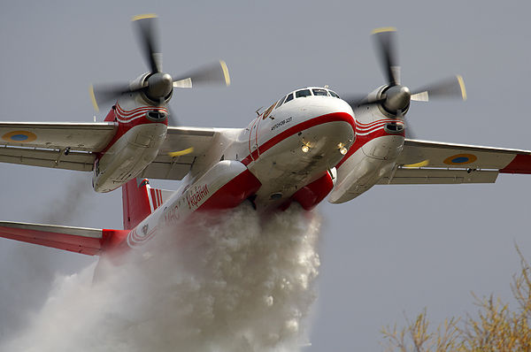 A State Emergency Service of Ukraine An-32 firefighting aircraft dumps water on a forest fire.