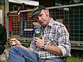 Man in Australia sitting in a camping chair with a tinnie (can of beer) and jar of vegemite