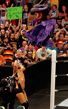 Neville performing a springboard moonsault on Curtis Axel Neville Moonsault in March 2015.jpg