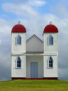 Simple white building with two red domed towers