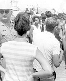 Schwarz-Weiß-Foto von Segregationisten, Autobahnpolizei und schwarzen Demonstranten an einem "nur weißen" Strand