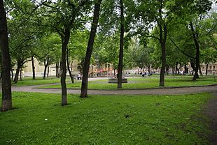 Photo d'un parc arboré, avec des jeux pour enfants.