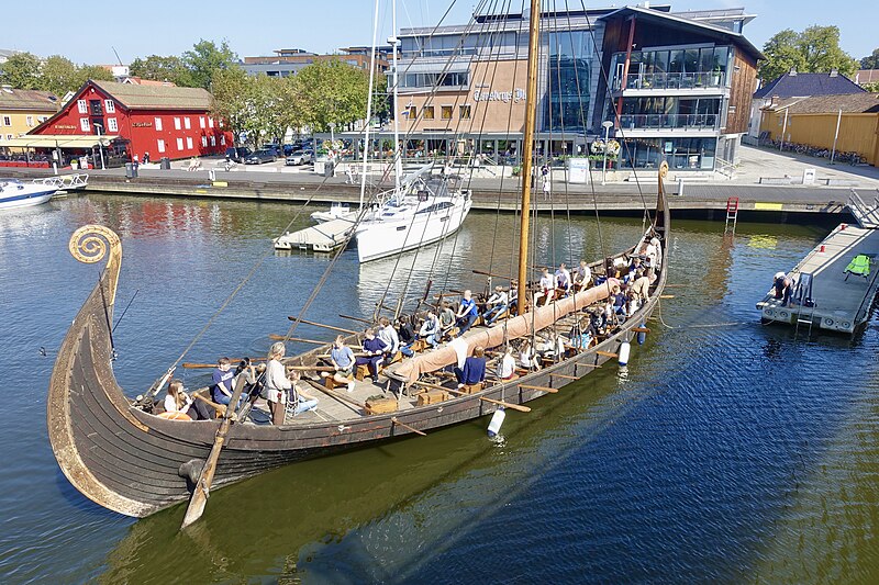 File:Saga Oseberg viking ship replica Tønsberg Norway Young students mooring Byfjorden Harbour havn Brygga pier board walk Aft stern akter Rudder ror Tønsbergs Blad Viewed from Kaldnes bro footbridge 2019-08-26 blurry faces 5132.jpg