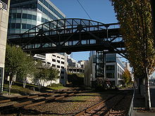 Part of the Bell Street Bridge, spanning railroad and trolley tracks. To the right, the footbridge continues across Alaskan Way to Pier 66. The 2006 Department of Neighborhoods definition includes all of this in the Central Waterfront; other definitions exclude it or are ambiguous about the matter.