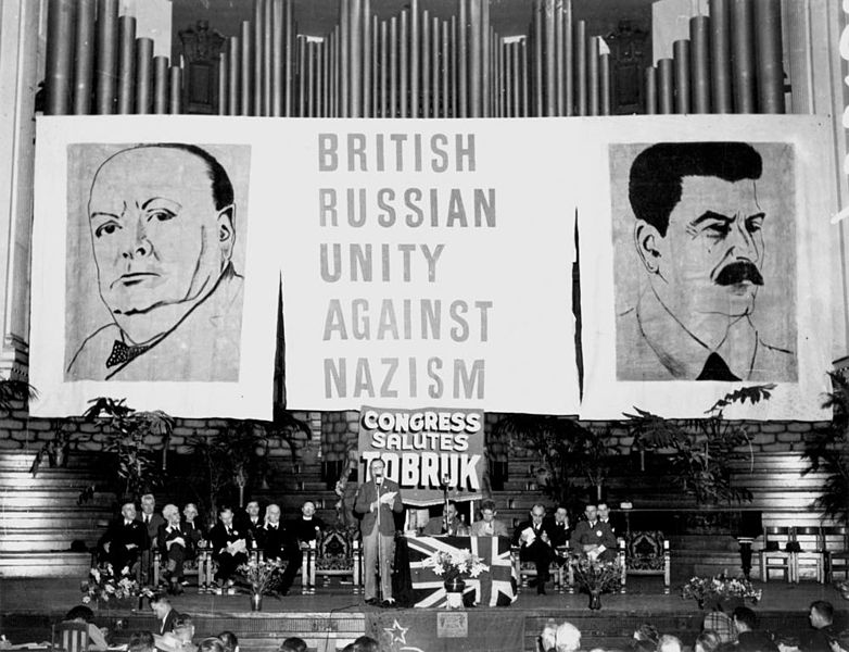 File:StateLibQld 2 108020 Guests seated on stage in front of a backdrop of giant posters at the Aid to Soviet Congress, Brisbane City Hall, October 1941.jpg