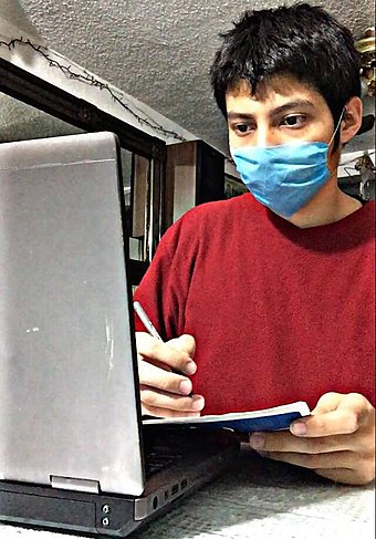 A student in Mexico wearing a surgical mask while taking classes at home. This occurred in April 2020, at the beginning of the pandemic, when the risks of contagion were not yet well known.