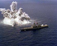 An explosive charge is detonated off the starboard side of the nuclear-powered guided missile cruiser USS Arkansas during a shock test, 17 March 1982 USS Arkansas (CGN-41) shock trials.jpg