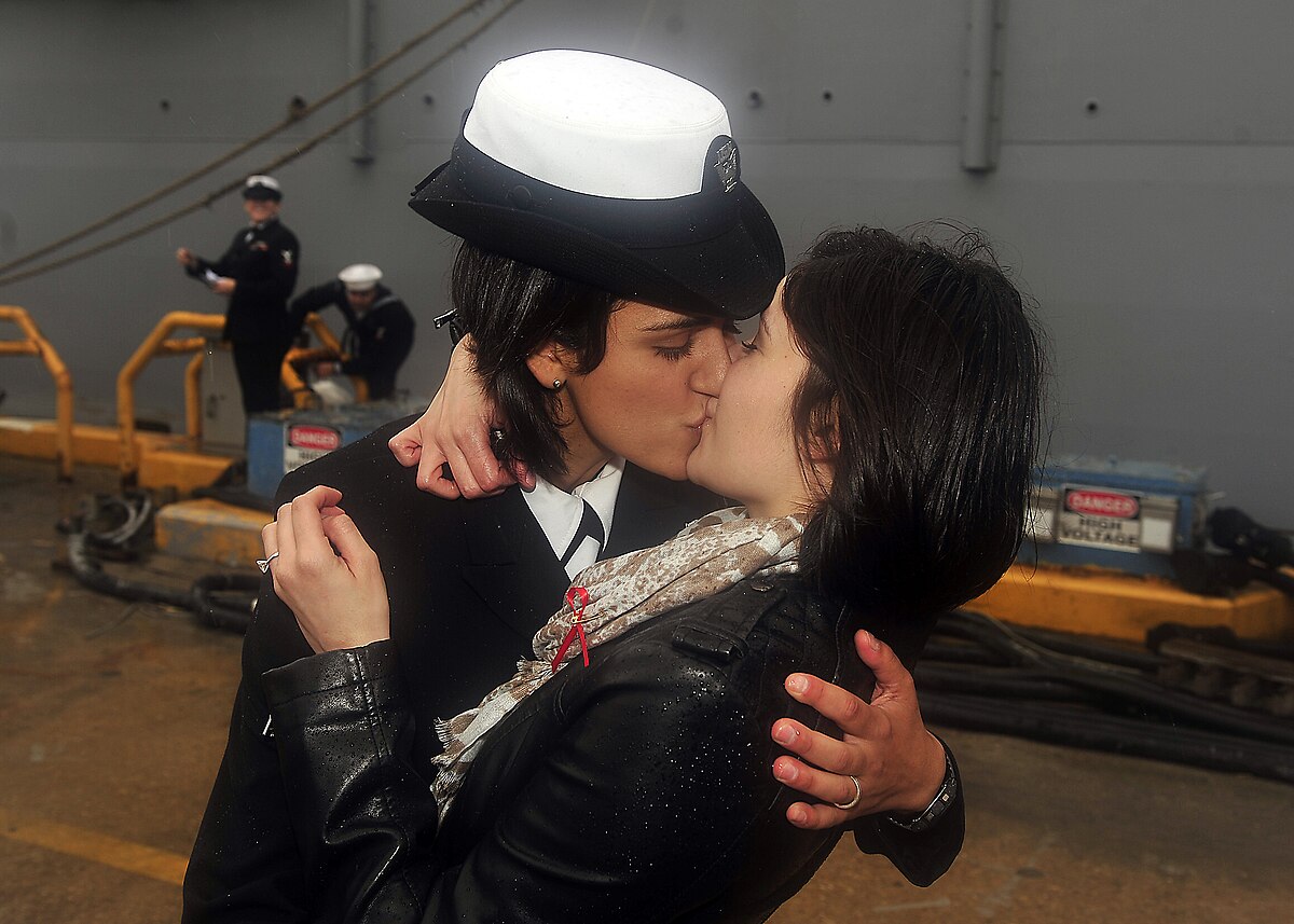 Traditional first kiss upon return of USS Oak Hill exchanged between two  lesbian sailors 