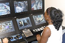 Una guardia di sicurezza controlla le telecamere a circuito chiuso di un negozio.