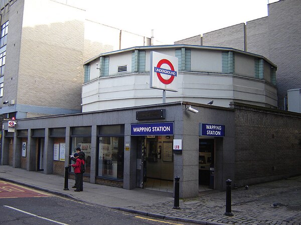 Wapping station as it appeared in 2006 with London Underground branding. The entrance has since been moved from the corner to the front.