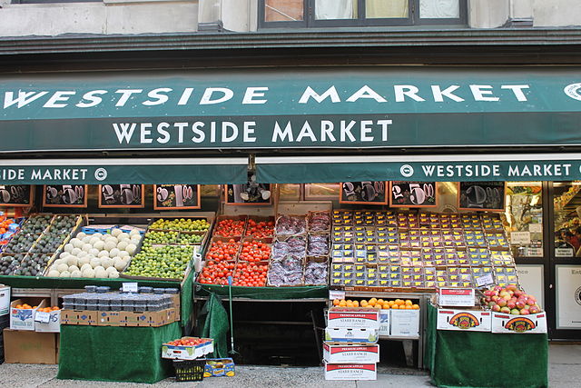 several shelves of produce displayed outside of a grocery store on the Upper West Side