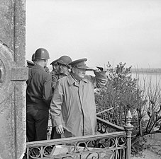 Churchill med amerikanska generaler på en balkong och tittar på allierade fordon som passerar Rhen, 25 mars 1945.