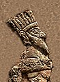Representació d'un rei amb corona, nu, empresonat per Anubanini. Deu ser una corona de plomes com la que es veu en alguns bronzes de Lorestan.[13] Relleu rocós d'Anubanini