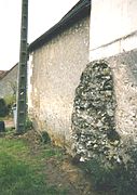 Uitzicht op een stenen massief gedeeltelijk ingebed in een moderne muur.