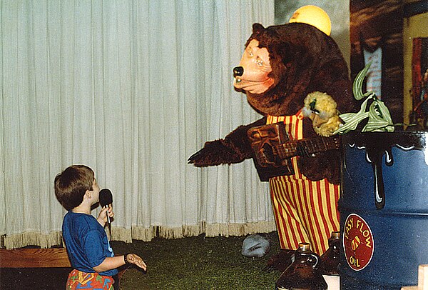 A Billy Bob animatronic with a child at a ShowBiz Pizza Place