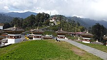 A close view of Dochula Pass with the Druk Wangyal Chortens with the monastery called the Druk Wangyal Lhakhang at the far end Dachul pass - Close view of stupas or chortens called Druk Wangyal Chortens and the monastery at the far end.jpg