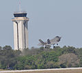 The F-35 Lightning II Joint Strike Fighter test aircraft AA-1 performs a touch-and-go maneuver with the Eglin Air Force Base control tower in the background.