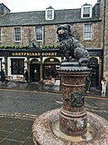 Thumbnail for File:Greyfriars Bobby statue, with the Greyfriars Bobby pub in the background.jpg