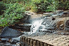 Lingas and sculptures of Hindu gods and waterfall at Kbal Spean