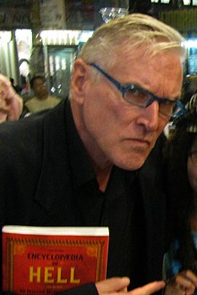 Martin Olson holding his book Encyclopedia of Hell in 2013