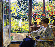 Jonge vrouw lezend bij het raam