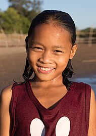 Portrait of a smiling girl with wet face in the sunshine at golden hour