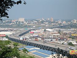 Downtown Kansas City on the hill above the I-70 Lewis and Clark Viaduct from Quality Hill. The tallest building on the right is Cross Lines Tower. The tallest building on the left is City Hall. The columned building by it is the Wyandotte County courthouse. (2006)