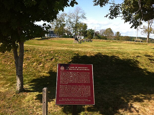 Raid on Lunenburg (1782) – National Historic Sites of Canada Plaque with earthworks of Blockhouse Hill in background, Lunenburg, Nova Scotia