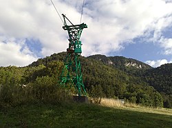 Vista dell'unico pilone rimasto della cabinovia nel 2015, integrato in un percorso avventura, con la vetta del Moucherotte sullo sfondo.