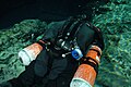 Sidemount diver in cave showing 2 cylinders and BC back view