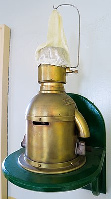 An 85 millimetres (3.3 in) Chance Brothers Incandescent Petroleum Vapour Installation which produced the light for the Sumburgh Head lighthouse until 1976. The lamp (made in approx. 1914) burned vaporized kerosene (paraffin); the vaporizer was heated by a denatured alcohol (methylated spirit) burner to light. When lit, some of the vaporised fuel was diverted to a Bunsen burner to keep the vaporizer warm and the fuel in vapor form. The fuel was forced up to the lamp by air; the keepers had to pump the air container up every hour or so, pressurizing the paraffin container to force the fuel to the lamp. The "white sock" pictured is an unburnt mantle on which the vapor burned. Sumburgh Lighthouse Lamp.jpg