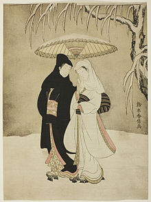 Мужчина и женщина в кимоно и платках идут по снегу.