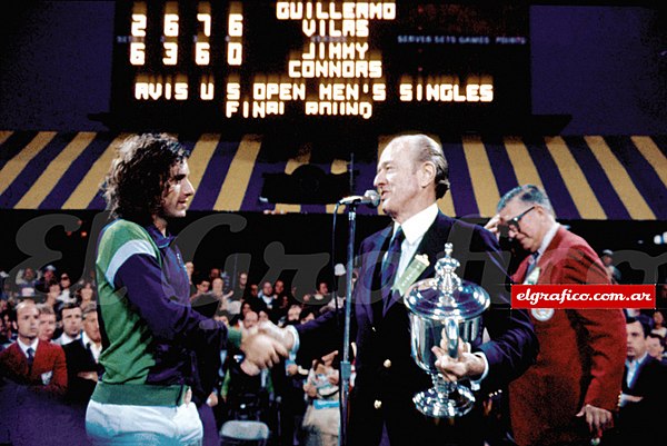 Guillermo Vilas being awarded with the trophy after defeating Jimmy Connors at the final