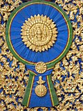 A woodcarving of "Maha Surabhorn", the Knight Grand Cross (First Class) of the Order of the Crown of Siam, version that used from 1869-1909, at gates of Phra Vihara of Wat Ratchabophit Sathit Maha Simaram, Bangkok.