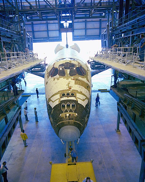 Columbia in the Orbiter Processing Facility after delivery to Kennedy Space Center in 1979. About 8,000 of 30,000 tiles had not yet been installed.