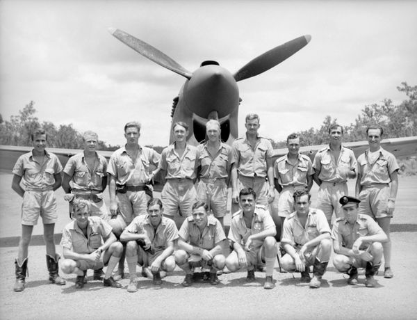 Pilots of B Flight, No. 77 Squadron, including Flying Officer John Gorton (back row, fourth from left) with a P-40 Kittyhawk in the Northern Territory