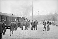 American and British soldier trainmen standing about at a station on the route for supplies to Russia. An American engine is seen at the head of the train at left, somewhere in Iran.jpeg