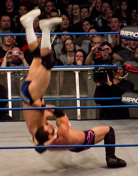 Austin Aries performing a brainbuster to Mark Haskins.