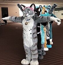 Fursuiters posing; the frontmost in a classic T-pose Fursuiters in T-Pose (48499221942) (cropped).jpg