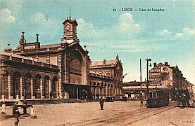 La gare avec publicités murales, tram et fontaine Montefiore.