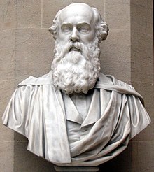 A stone head and shoulders bust of a balding man with a full beard and sideburns