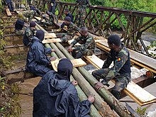 Cameroonian soldiers repairing a bridge while moving towards Wum, December 6. Les militaires Cameroun sur un pont, en direction de Wum, en zone anglophone, le 6 decembre 2018.jpg