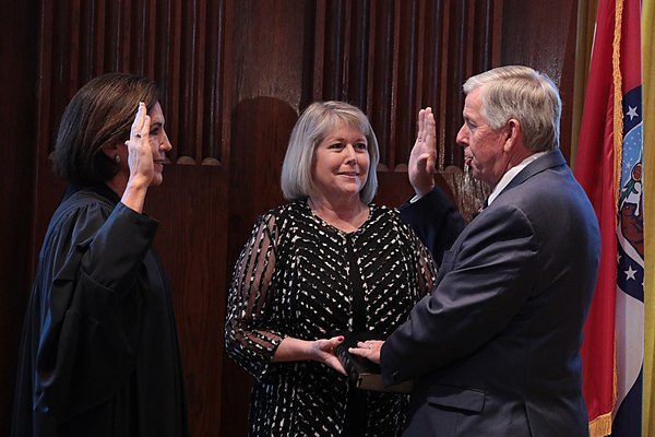 Parson being sworn in as Governor of Missouri in 2018 by Mary Rhodes Russell alongside his wife Teresa