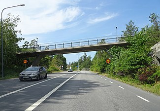 Norra Kungsvägen västerut med gång- och cykelbron vid Rudboda skola.
