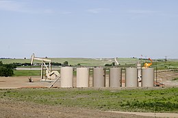 Petroleum extraction and storage with flaring of the associated gas at a rural site. Orvis State oil well and gas tanks and natural gas flare - Evanson Place - Arnegard North Dakota - 2013-07-04 (9287569795).jpg