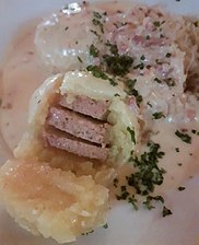 Gefüllte: Kartoffelklöße gefüllt mit Leberwurst, mit Specksauce und Sauerkraut.