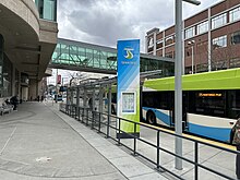 High-performance transit station at Plaza Bay 6. The stop includes STA branding, real-time bus information, glass shelter, lighting, and seating. Spokane Transit Plaza Bay 6.jpg