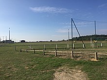 Kleurenfoto van een grasveld met diverse sportfaciliteiten.