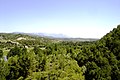 La vall del curs baix de la Ribera Salada. Al fons, el massís del Port del Comte on té la seva capçalera